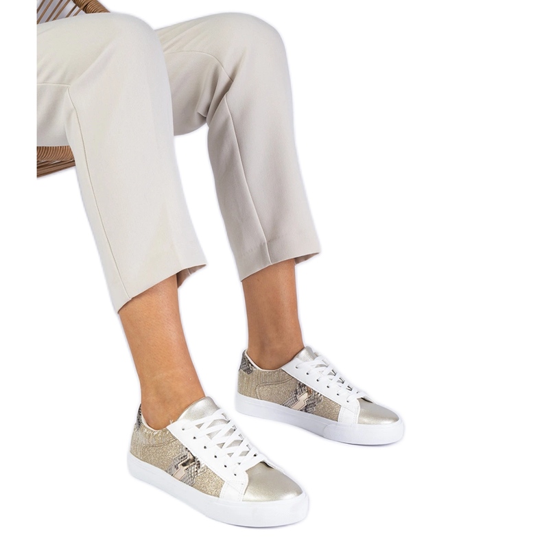 Goldene Turnschuhe mit einem Tiermotiv, das mit Glitzer verziert ist