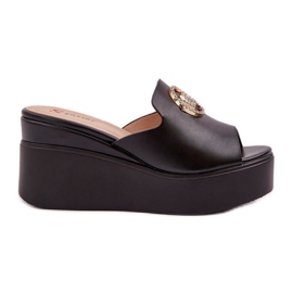 Hausschuhe auf der Plattform und Keile mit einer schwarzen Dekoration