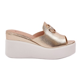 Hausschuhe auf der Plattform und Keile mit einer goldenen Verzierung