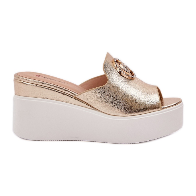 Hausschuhe auf der Plattform und Keile mit einer goldenen Verzierung