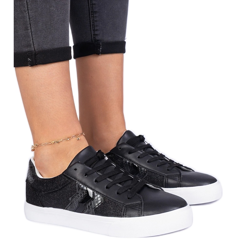 Schwarze Turnschuhe mit einem Tiermotiv, das mit Glitzer verziert ist