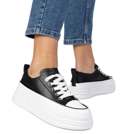 Schwarz -Weiß -Frauen -Turnschuhe auf einer hohen Sohle