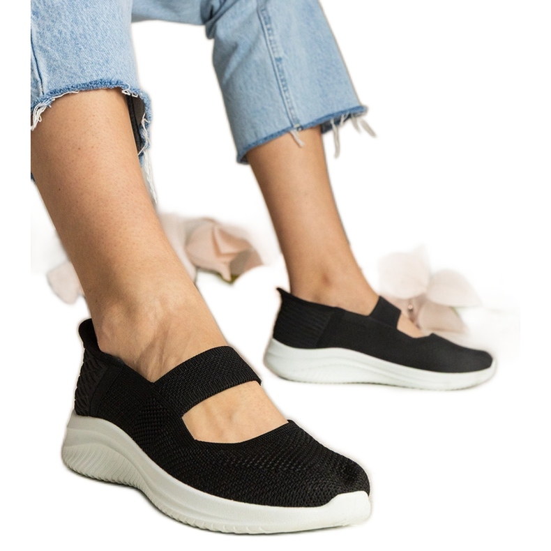 Schwarze Frauen -Turnschuhe auf einer gepressten Sohle