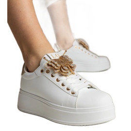 Weiße und Gold -Turnschuhe mit einem Schmetterling mit Zirkonen dekoriert
