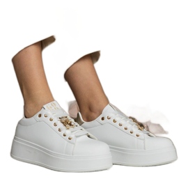 Weiß- und Gold -Sneaker von Frauen mit Steinen dekoriert