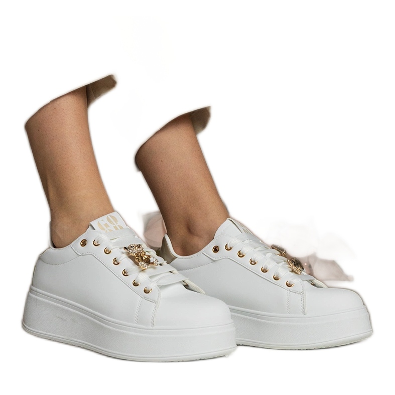 Weiß- und Gold -Sneaker von Frauen mit Steinen dekoriert