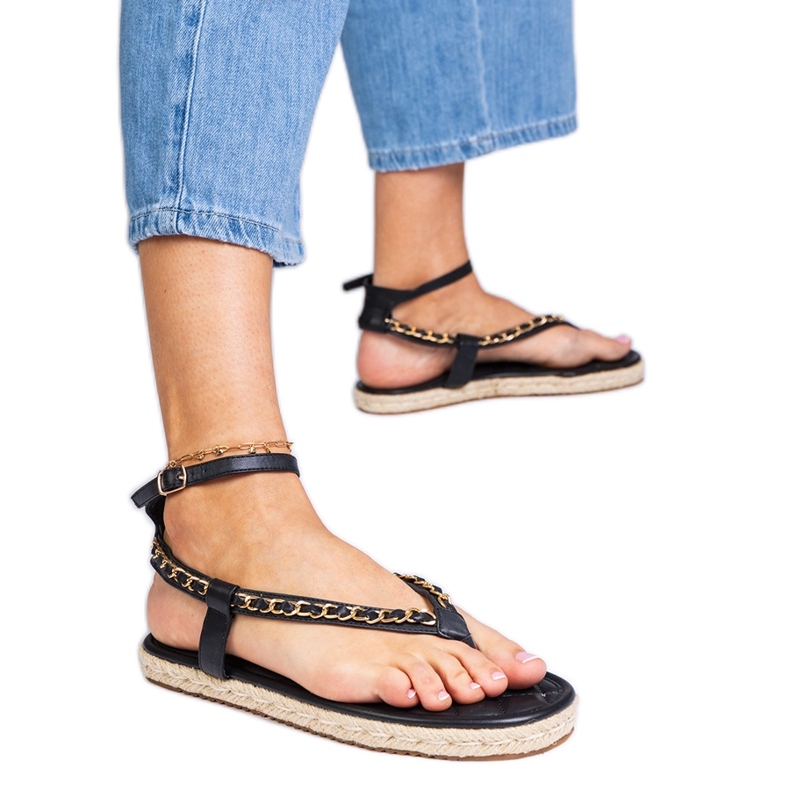Schwarze Sandalen mit einer Kette dekoriert