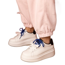 Weiße Sport -Turnschuhe auf der Plattform