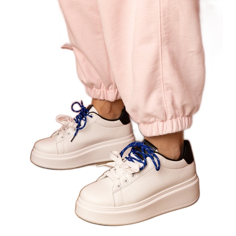 Weiße Sport -Turnschuhe auf der Plattform