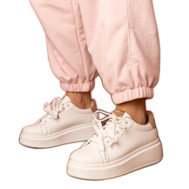 Weiße und goldene Sport -Turnschuhe auf der Plattform