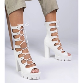 Weiße Stiefel auf einer hohen Säule mit Ausschnitten