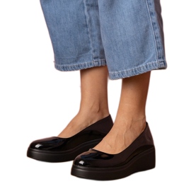 Schwarze Schuhe, die auf der Plattform lackiert sind