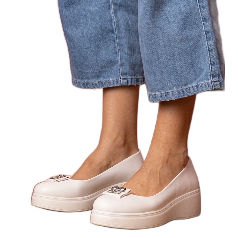 Weiße Schuhe auf der Plattform mit einer Zirkondekoration