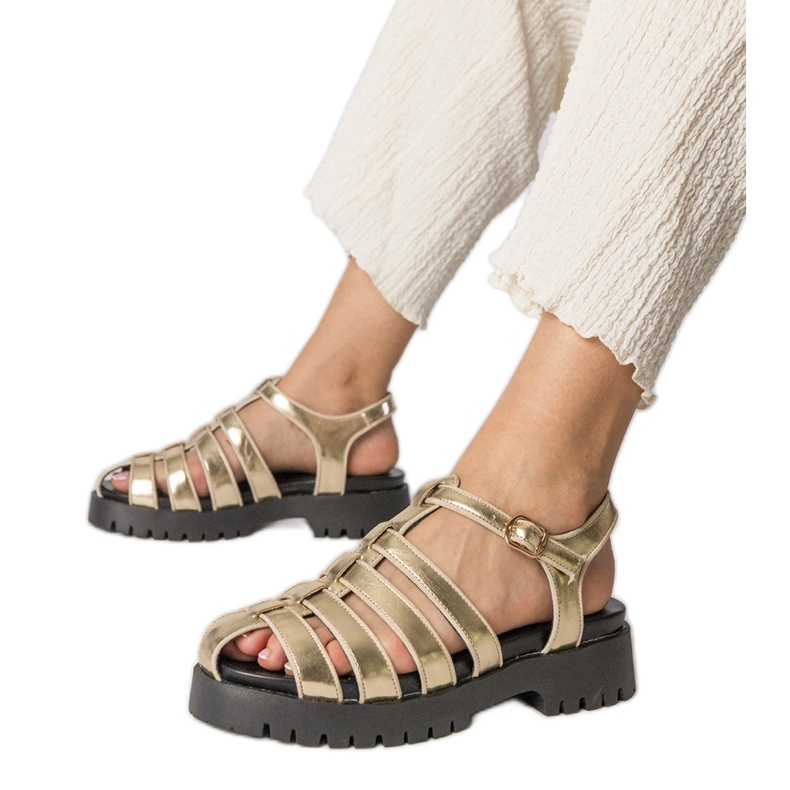 Goldsandalen auf der Plattform mit einer Fingerlinie gebaut golden