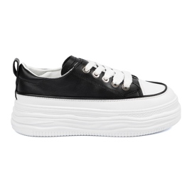 Schwarze und weiße Turnschuhe auf der Plattform