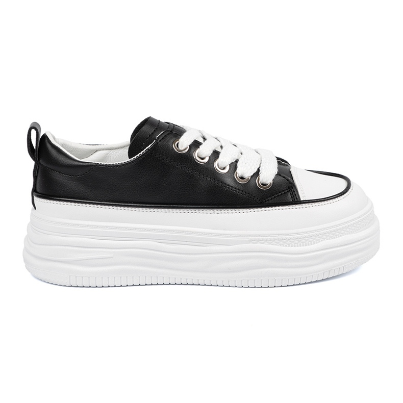 Schwarze und weiße Turnschuhe auf der Plattform