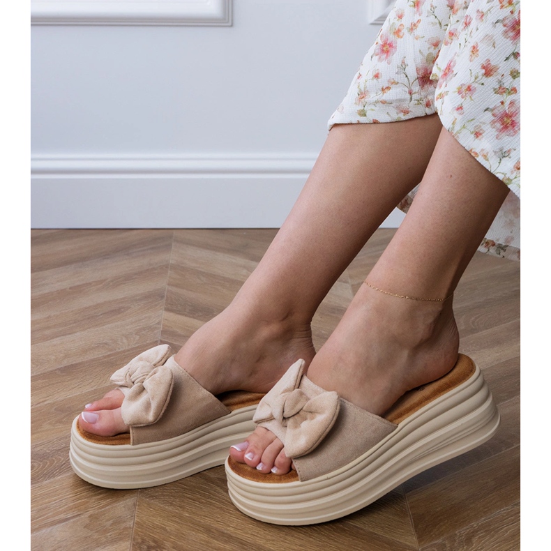 Braune Flip Flops auf der Plattform mit einem Bogen
