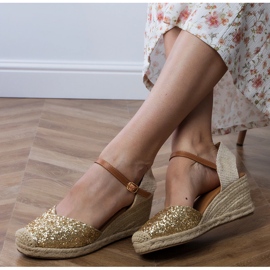 Goldene Brokat -Sandalen auf einem Keil