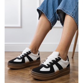 Schwarze Turnschuhe der Frauen auf der Plattform