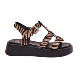 Frauensandalen auf der Plattform mit einem goldenen Detail des beige-schwarzen Zebras