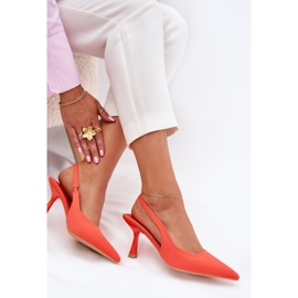 Frauensandalen an einer orangefarbenen Stecknadel