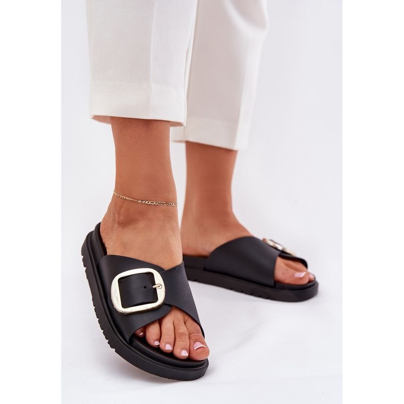 Die Flip -Flops für Frauen auf der Plattform mit einer goldenen Klemme schwarz