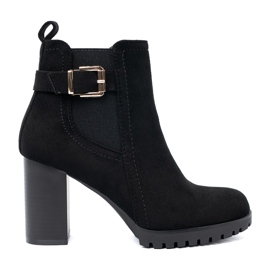 Shelvt Schwarze Stiefel auf dem Pfosten mit einer dekorativen Klemme