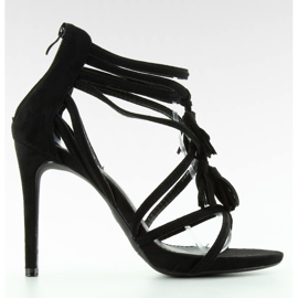 Sandalen an einem Stift mit schwarzen Quasten