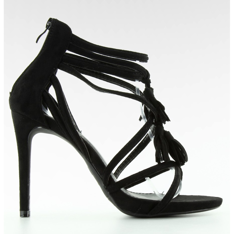 Sandalen an einem Stift mit schwarzen Quasten