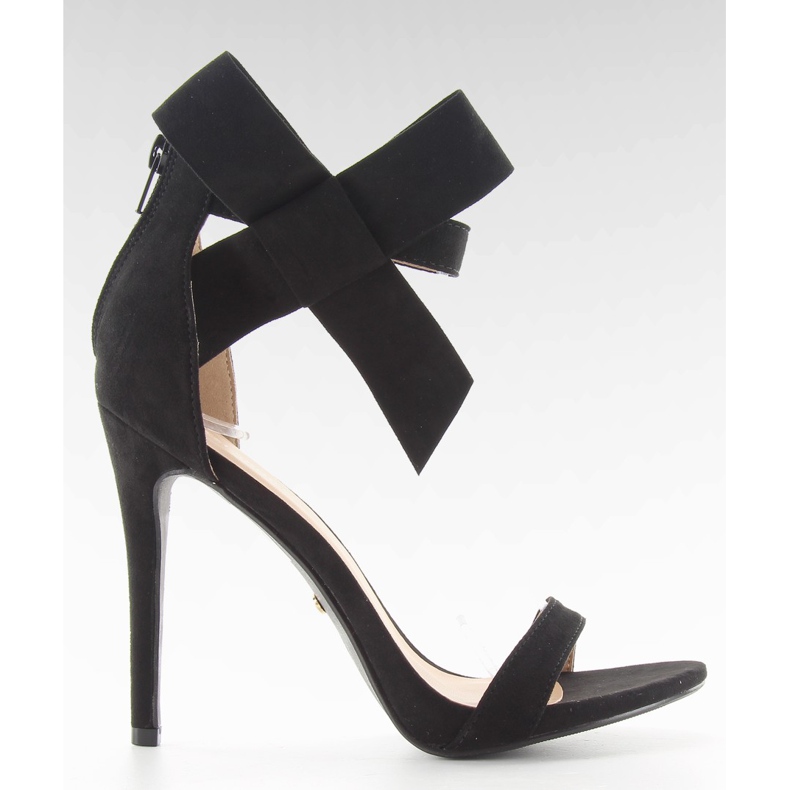 Sandalen auf einer Nadel mit einer schwarzen Schleife