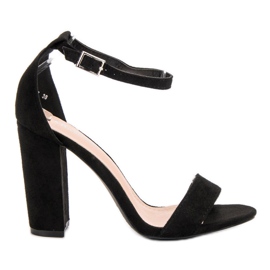 Ch. Creation Schwarze Sandalen auf einer Bar