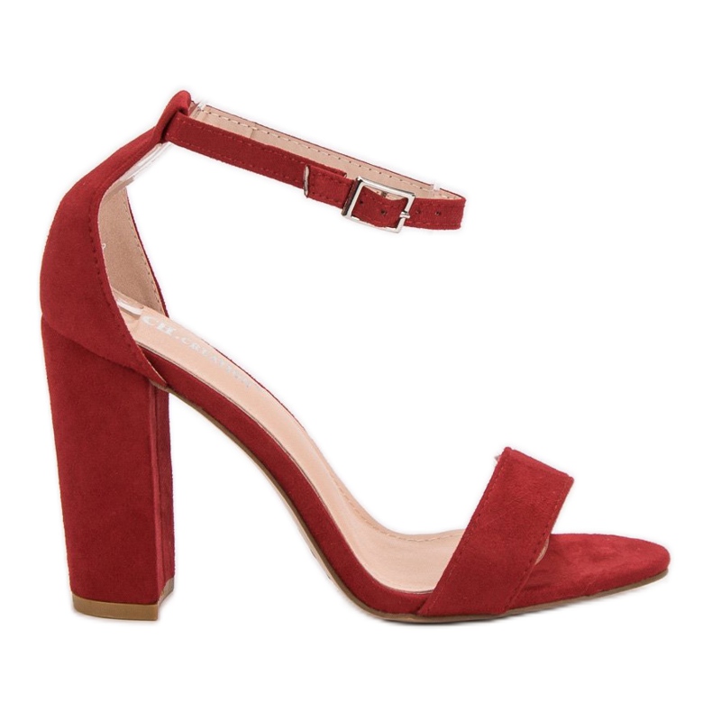 Ch. Creation Rote Sandalen auf einer Bar