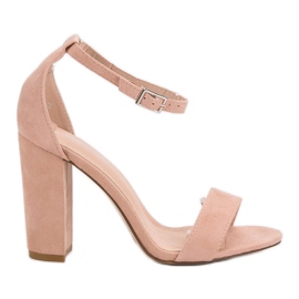 Ch. Creation Rosa Sandalen auf einer Bar