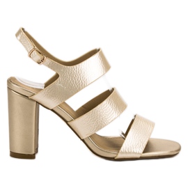 SHELOVET Goldene Sandalen an einer Bar