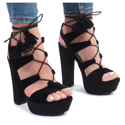 Schwarze Sandalen auf einem One Love Veloursposten