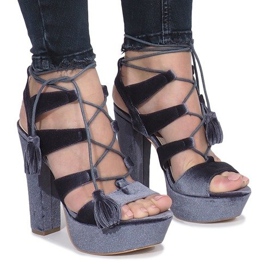 Graue Sandalen auf einem One Love Veloursposten