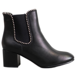 Janessa Elegante Chelsea-Stiefel an einer Bar schwarz