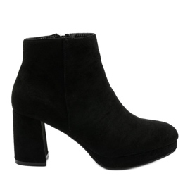 Schwarze Wildleder-Stiefeletten auf dem Mahagonis-Pfosten