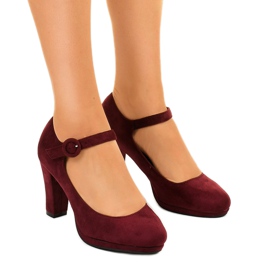 Kastanienbraune Wildlederpumps an der Liayarus-Säule rot