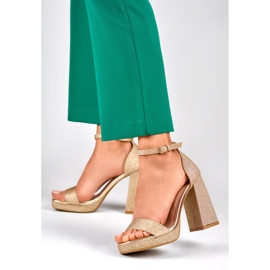 Goldglänzende Sandalen auf einem breiten hohen Absatz golden 2