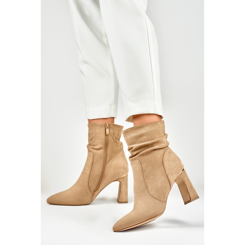 Beigefarbene Damenstiefel auf einem verzierten Pfosten 2