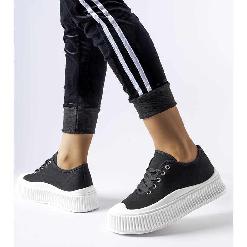 Schwarze Turnschuhe auf einem dicken weißen Rina-Plateau 1