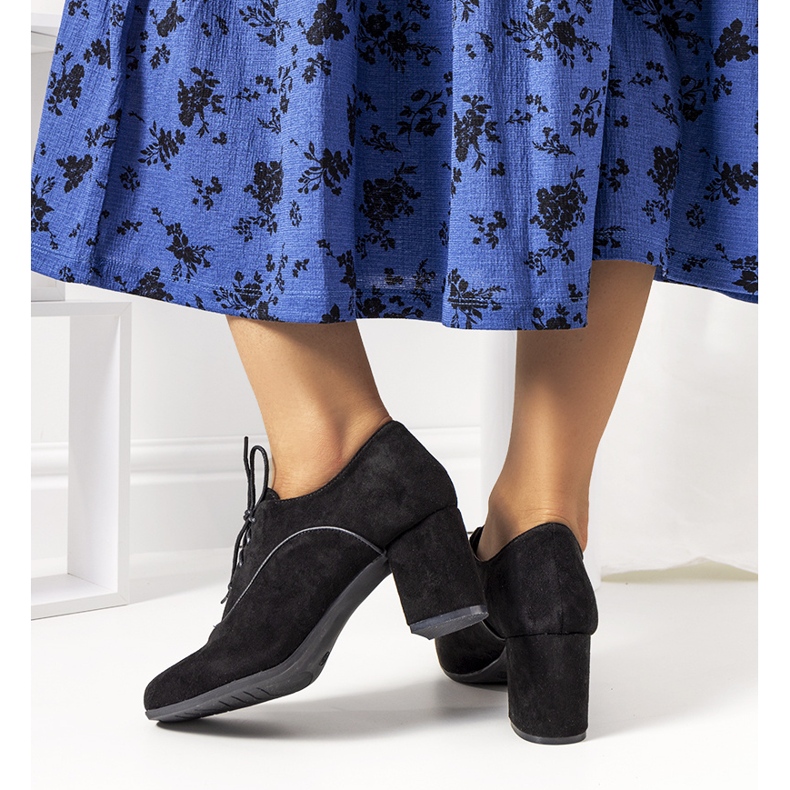 Schwarze Schuhe auf dem Vogelpfosten 2