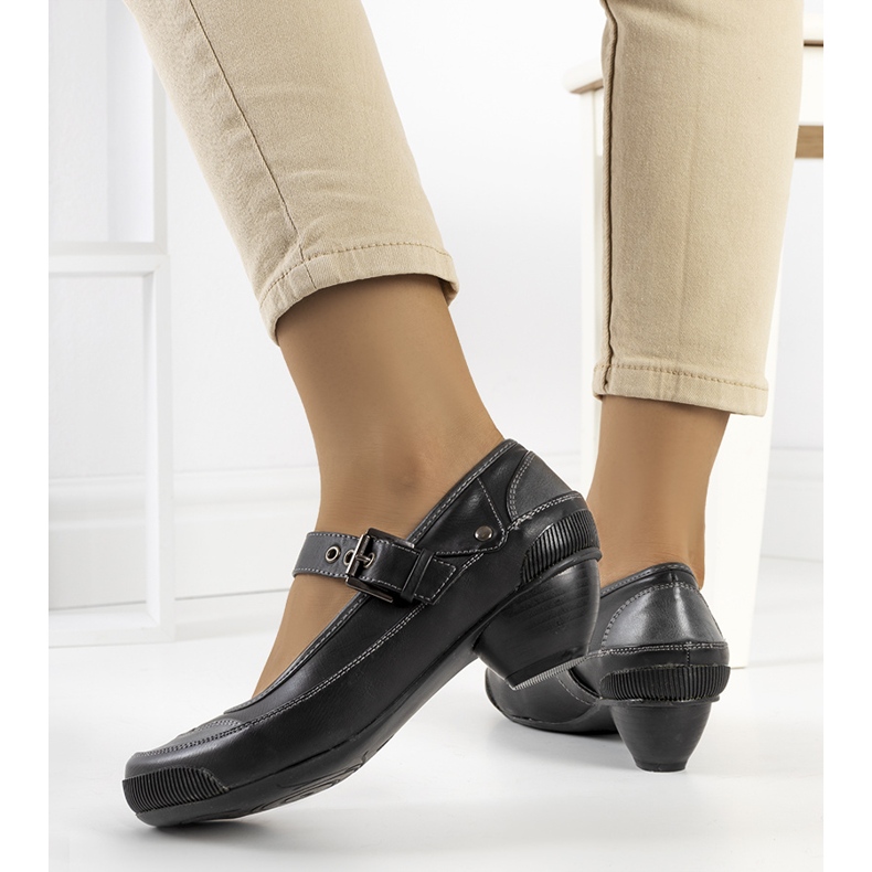 Schwarze Pumps, die mit einem Via-Riemen befestigt werden 1