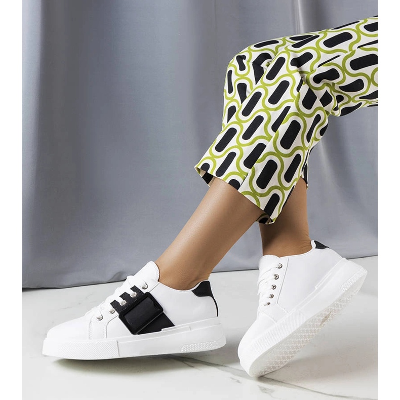 Weiße Turnschuhe mit einer schwarzen Erin-Schnalle 1