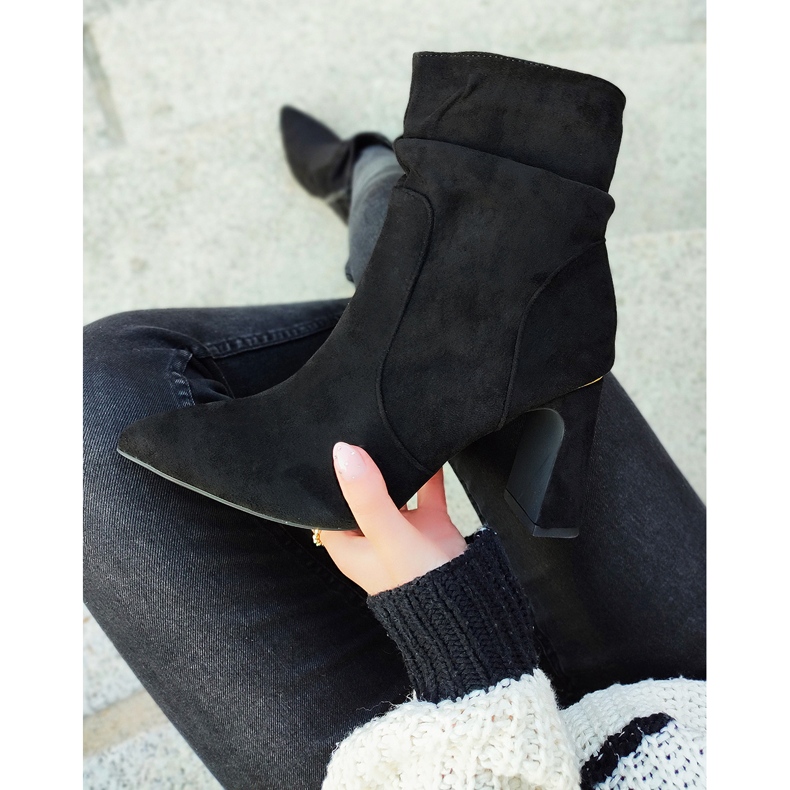 Schwarze Damenstiefel auf einem verzierten Pfosten 2