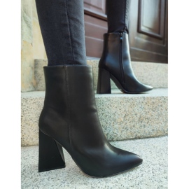 Schwarze Stiefel auf einem dreieckigen Pfosten 1