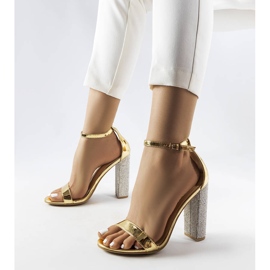 Goldene Sandalen auf einem dekorativen Rette-Pfosten 1