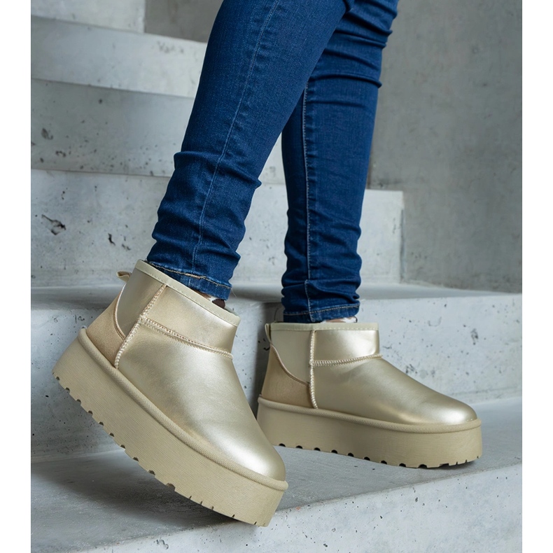 Goldene niedrige Schneestiefel auf der Plattform 1