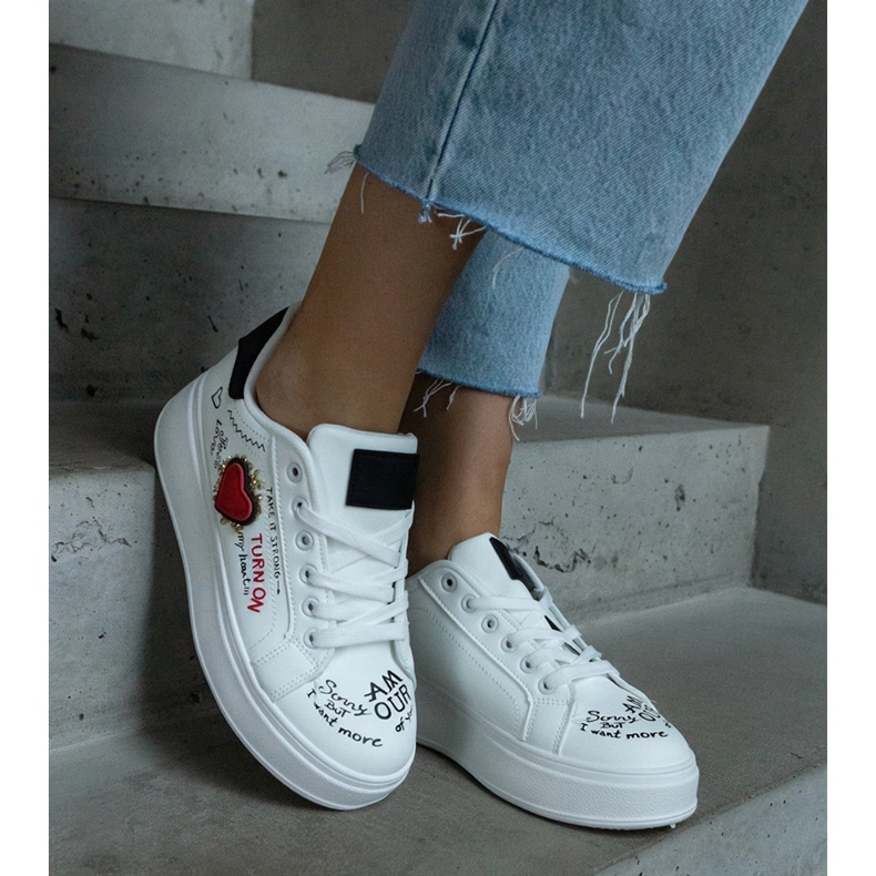 Weiße Sneakers, verziert mit einem Aufnäher und Aufschriften auf der Plattform 1